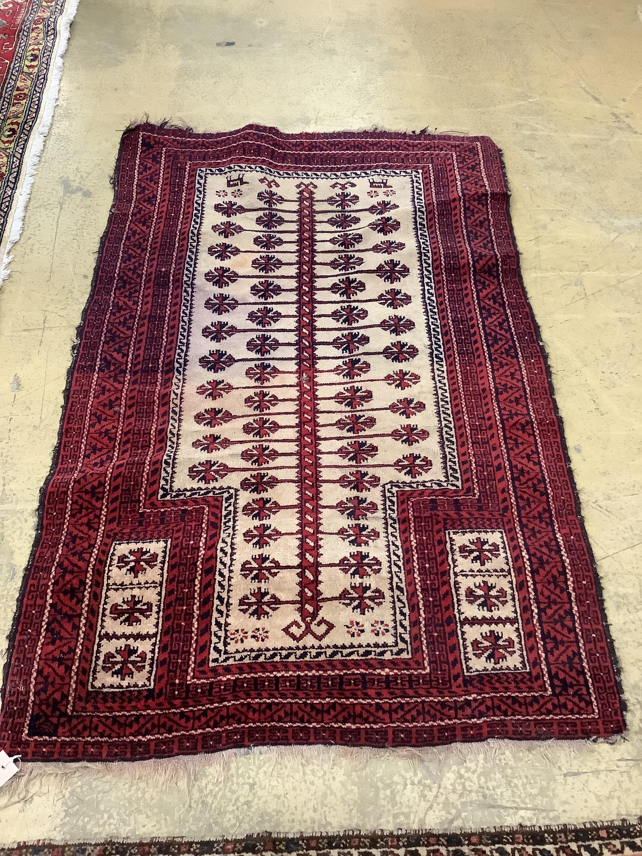 A North West Persian red ground carpet and a Belouch prayer rug, larger 300 x 216cm